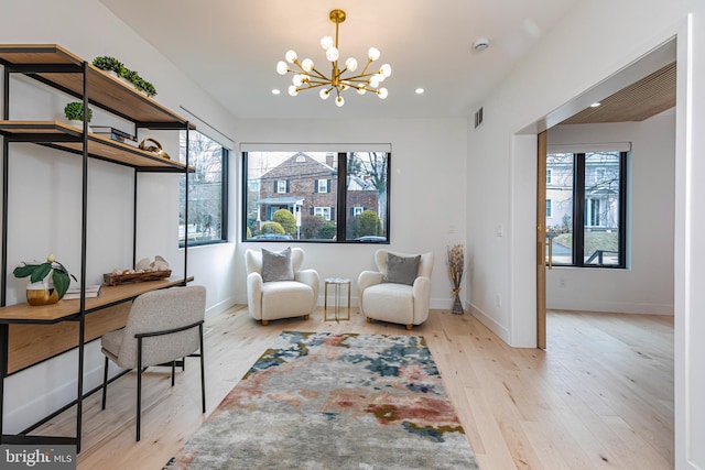 sitting room with baseboards, light wood finished floors, visible vents, and a healthy amount of sunlight