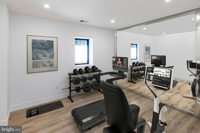 exercise room featuring baseboards, wood finished floors, and recessed lighting