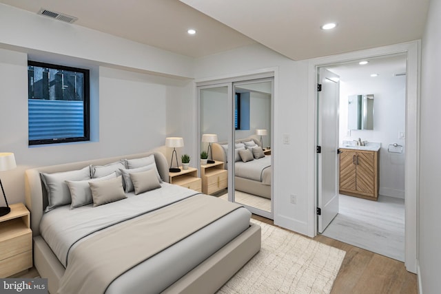 bedroom with recessed lighting, a sink, visible vents, baseboards, and light wood finished floors