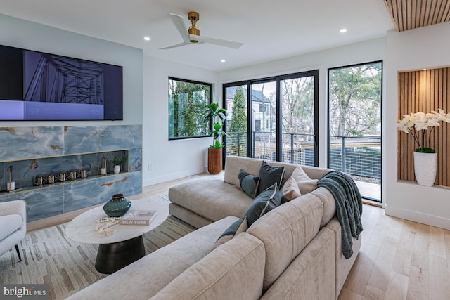 living room with baseboards, wood finished floors, and recessed lighting