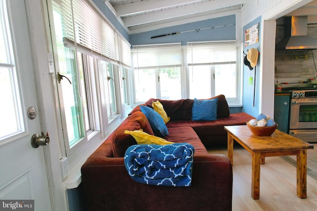 sunroom / solarium featuring lofted ceiling with beams