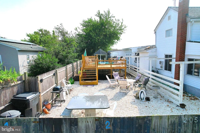 view of patio / terrace featuring grilling area, a deck, and a fenced backyard