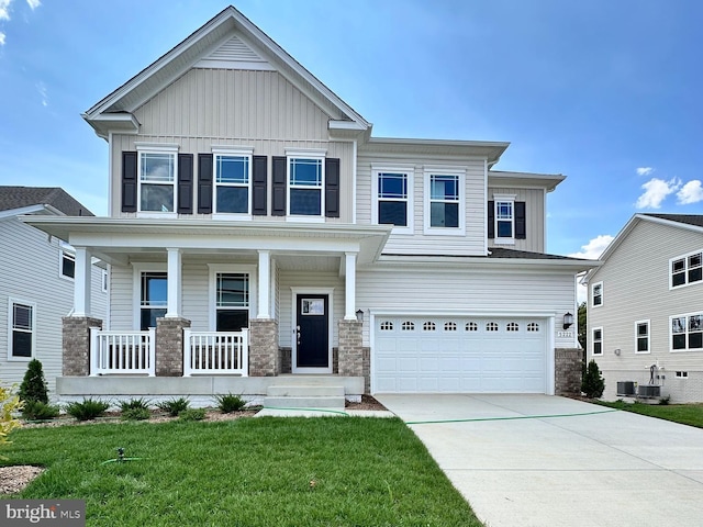 craftsman inspired home featuring a garage, concrete driveway, a porch, board and batten siding, and a front yard