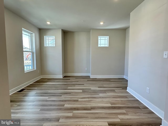 unfurnished room with baseboards, wood finished floors, and recessed lighting