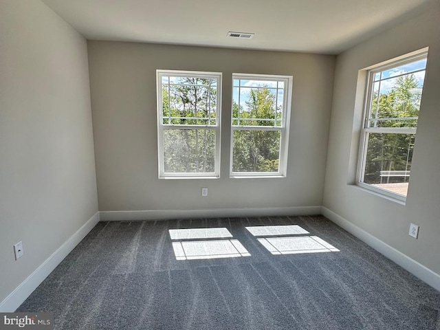 carpeted empty room with plenty of natural light, visible vents, and baseboards