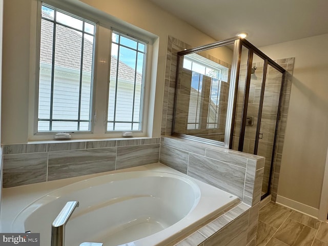 bathroom featuring a stall shower and a garden tub