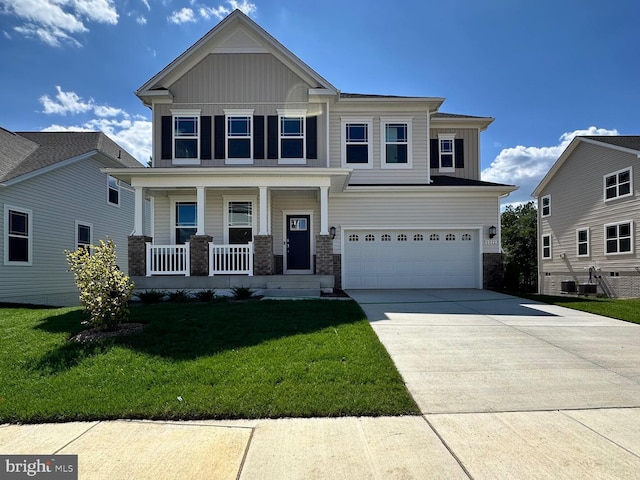 craftsman-style house with covered porch, an attached garage, board and batten siding, a front yard, and driveway