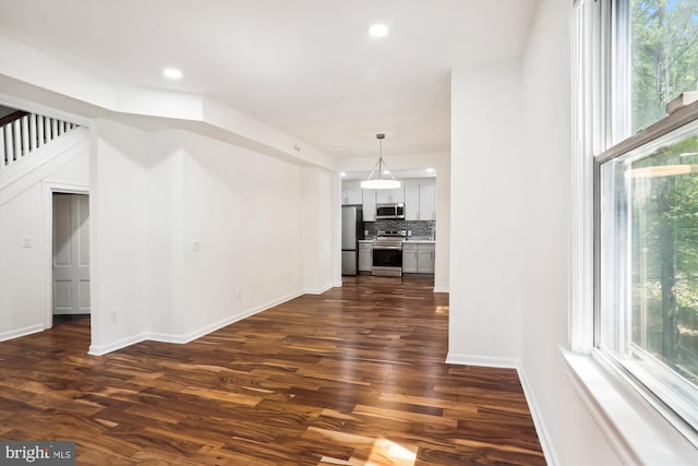 interior space featuring plenty of natural light, baseboards, dark wood finished floors, and recessed lighting