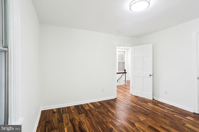 unfurnished room with dark wood-style floors and baseboards