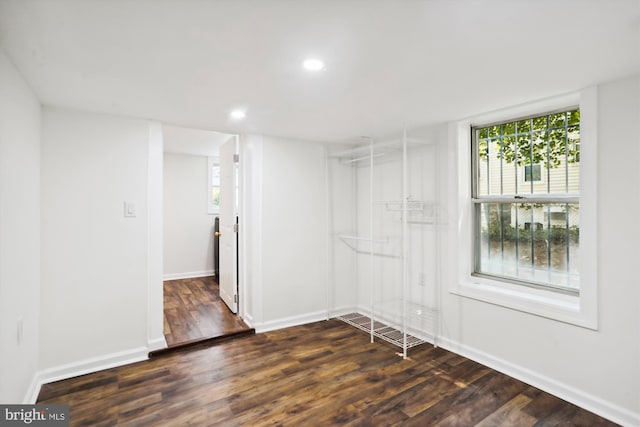 walk in closet with wood finished floors