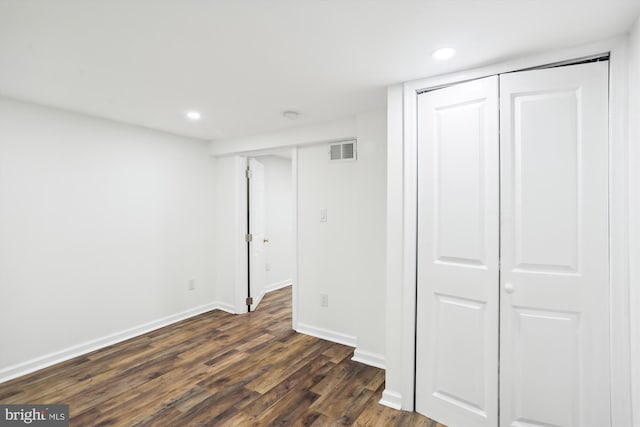 unfurnished bedroom featuring recessed lighting, dark wood-type flooring, visible vents, baseboards, and a closet