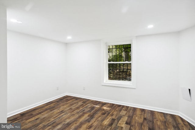 unfurnished room with dark wood-style flooring, recessed lighting, and baseboards