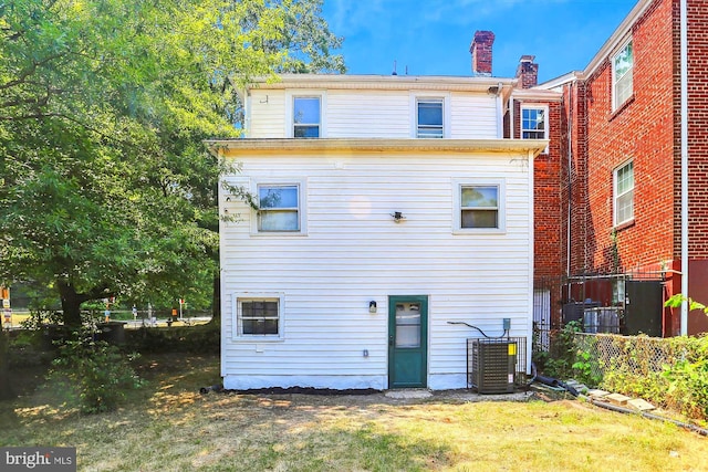 back of house with a yard and central AC unit