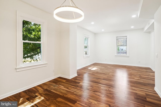 spare room with baseboards, wood finished floors, and recessed lighting