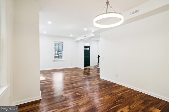 empty room with visible vents, baseboards, dark wood-type flooring, and recessed lighting