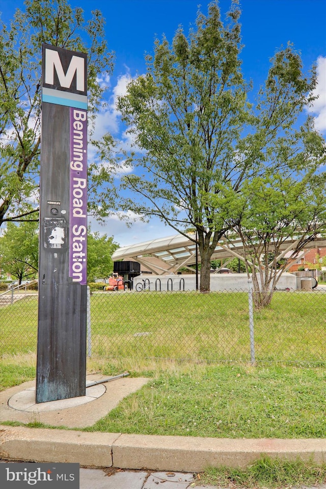 view of property's community featuring a lawn and fence