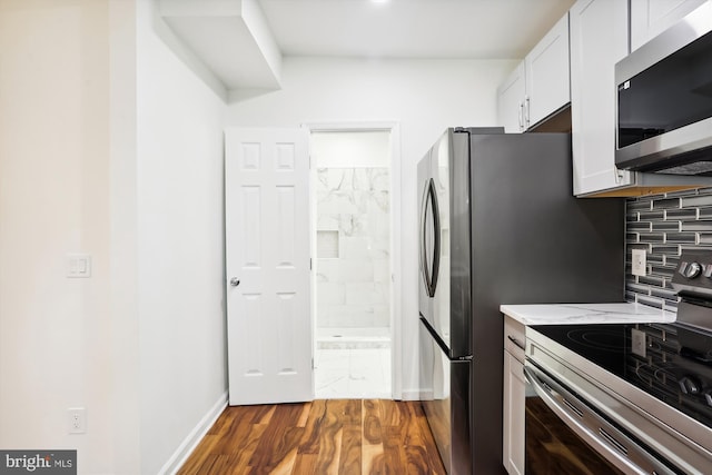 kitchen with baseboards, white cabinets, dark wood-style floors, appliances with stainless steel finishes, and backsplash