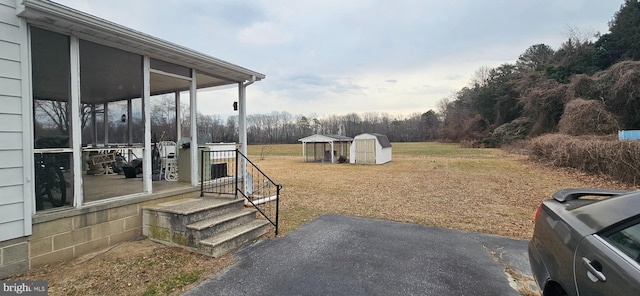 view of yard with a sunroom and an outbuilding