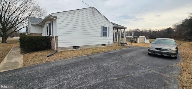 view of side of property with an outbuilding, a shed, and brick siding