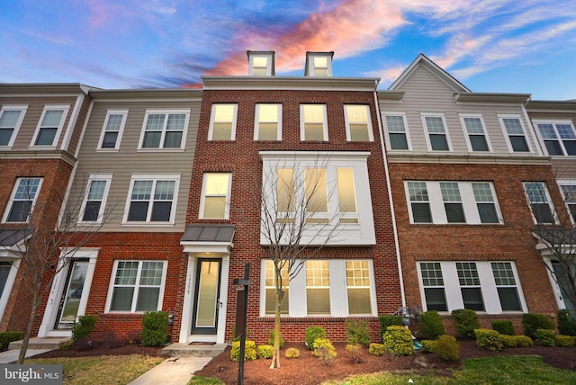 townhome / multi-family property featuring brick siding