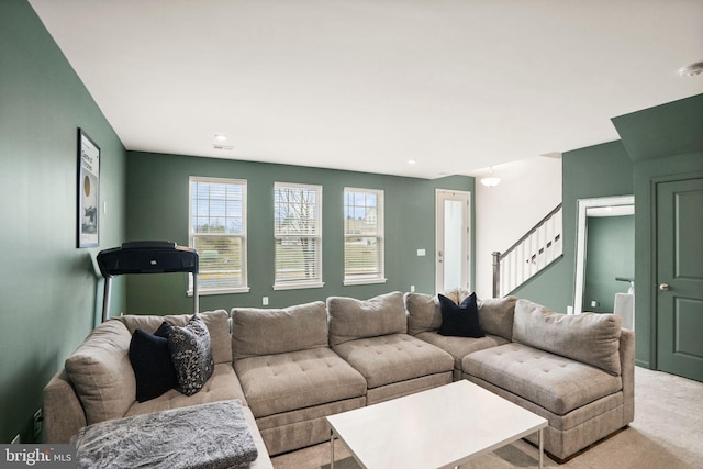 living room with stairway and light colored carpet