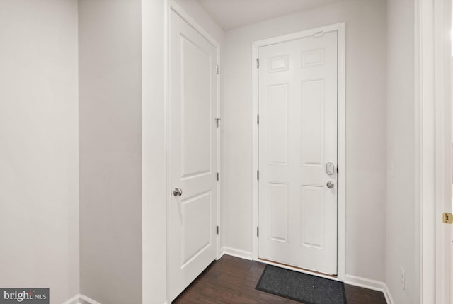 doorway with dark wood-style floors and baseboards