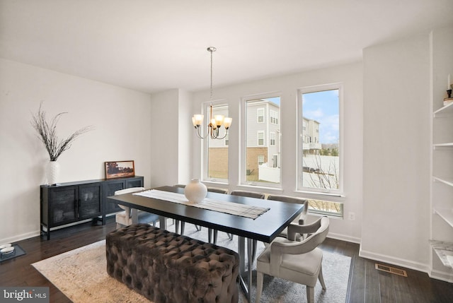 dining room featuring dark wood-style floors, visible vents, baseboards, and an inviting chandelier