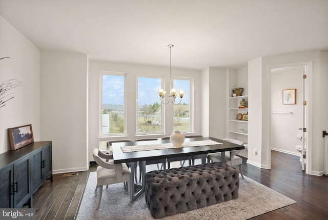 dining area featuring baseboards, a notable chandelier, and dark wood finished floors