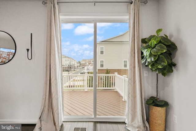 doorway to outside featuring wood finished floors and visible vents