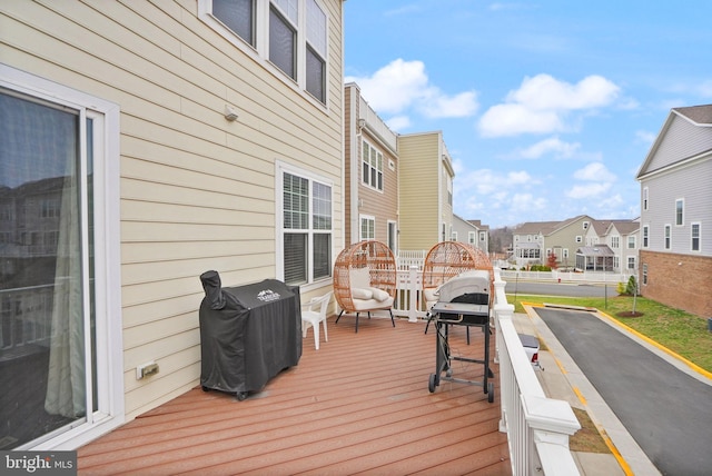 wooden terrace with area for grilling and a residential view