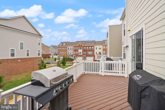 wooden deck with area for grilling and a residential view