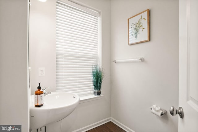 bathroom featuring a sink, baseboards, and wood finished floors