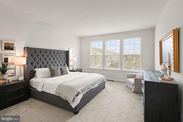 bedroom with baseboards and light carpet