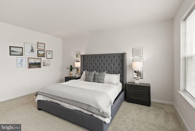 bedroom with light colored carpet, baseboards, and multiple windows