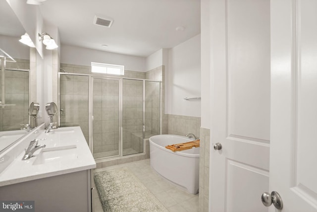 bathroom with visible vents, double vanity, a freestanding bath, a sink, and a shower stall