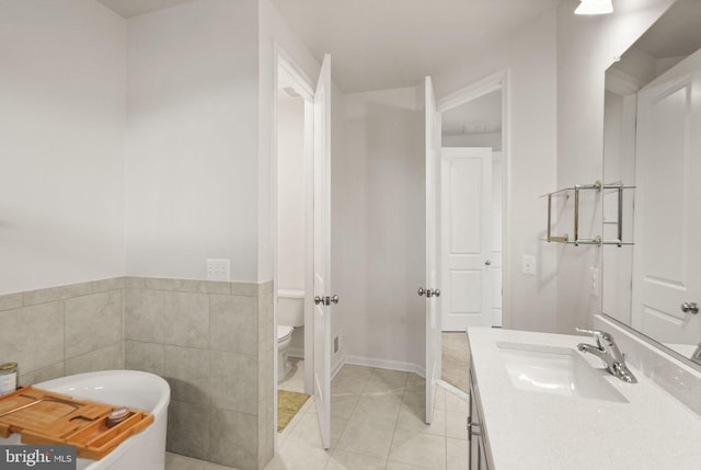 full bathroom with vanity, a soaking tub, tile walls, toilet, and tile patterned floors