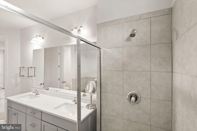 full bathroom with tiled shower, toilet, and a sink