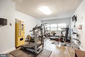 exercise area featuring wood finished floors and baseboards