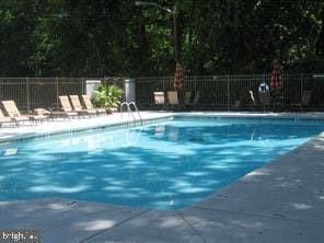 community pool featuring a patio area and fence