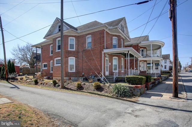 view of side of home with brick siding and a porch