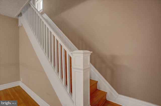 stairs featuring baseboards and wood finished floors