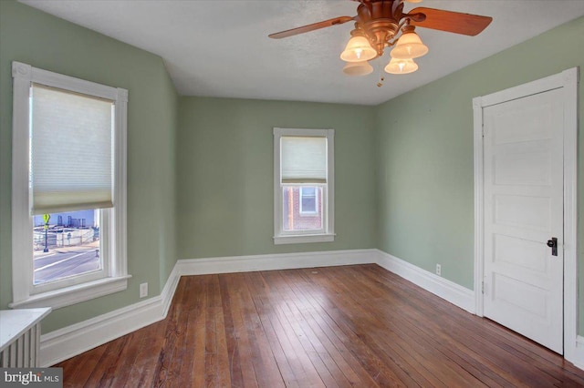 unfurnished room featuring hardwood / wood-style flooring, baseboards, and ceiling fan