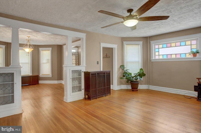 interior space featuring baseboards, light wood finished floors, and a textured ceiling