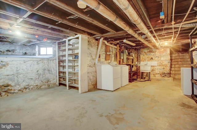 below grade area featuring a sink and washer and clothes dryer