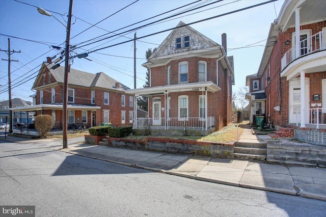 view of front facade with brick siding and covered porch