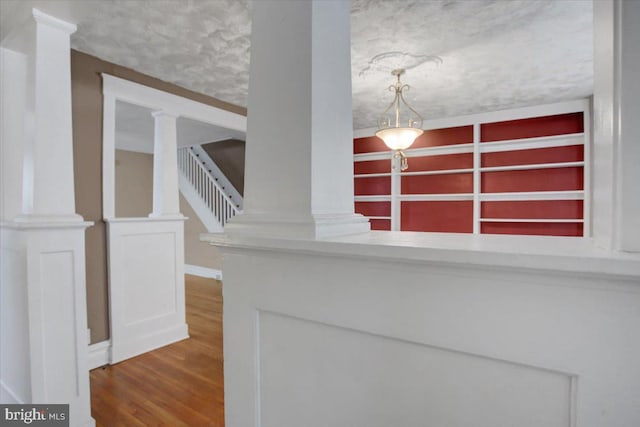 interior space featuring wood finished floors and ornate columns