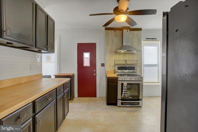 kitchen featuring decorative backsplash, stainless steel appliances, wall chimney exhaust hood, and light countertops