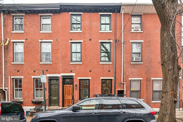 view of front of home featuring brick siding and cooling unit