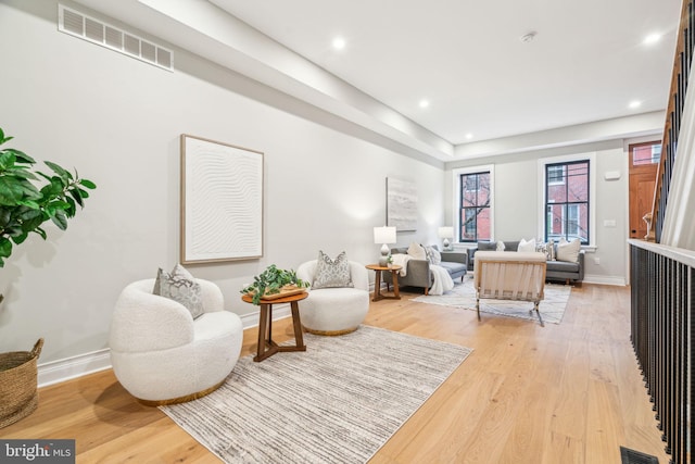 sitting room featuring light wood-style flooring, visible vents, baseboards, and recessed lighting