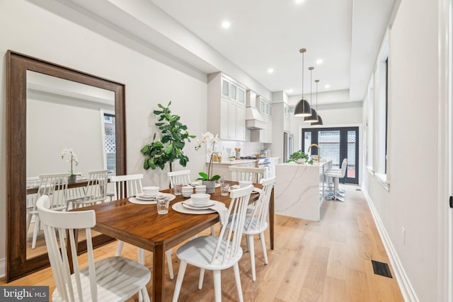 dining space with recessed lighting, light wood-type flooring, visible vents, and baseboards